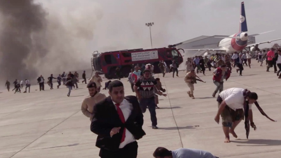 أشخاص يركضون بعد انفجار في مطار في عدن