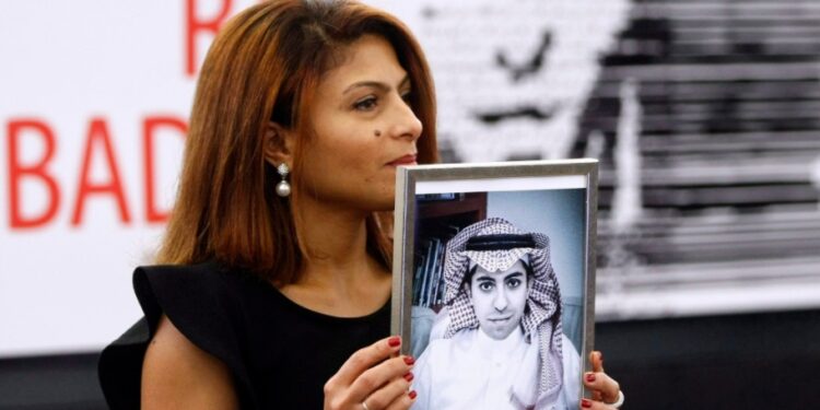 إنصاف حيدر تحمل صورة زوجها رائف بدوي