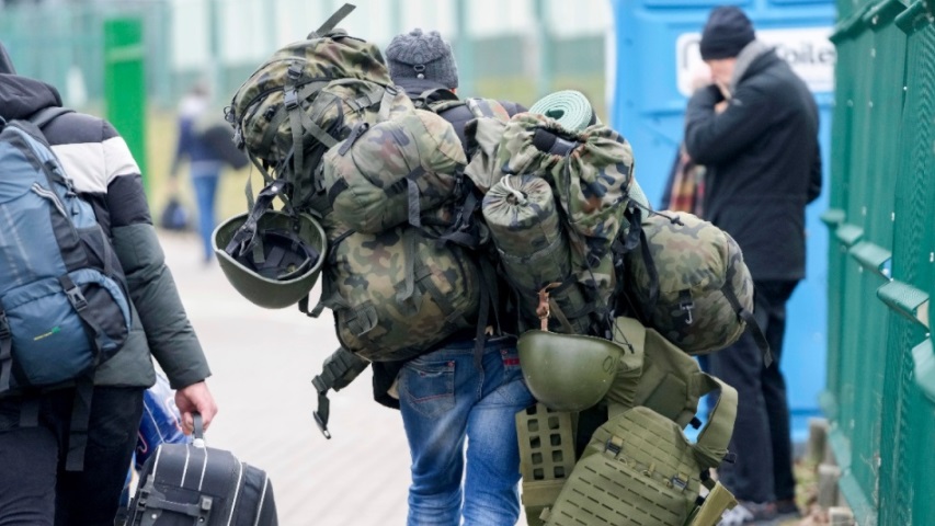 رجل يحمل معدات قتالية أثناء دخوله أوكرانيا عند المعبر الحدودي في Medyka ببولندا في 2 مارس 2022