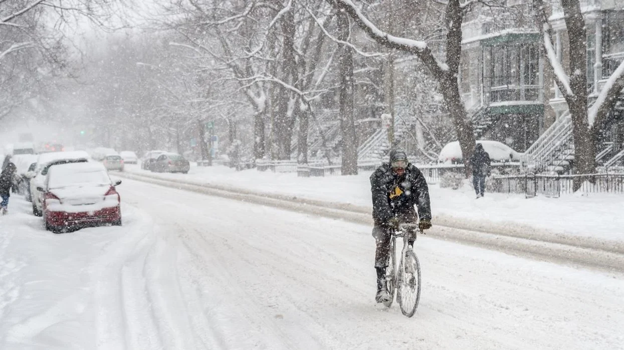 شخص يقود دراجته خلال الطقس العاصف في مونتريال