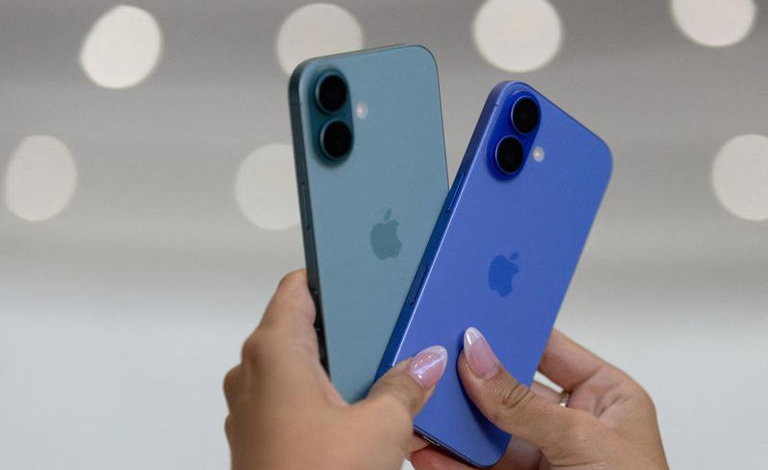An attendee holds two iPhones 16 as Apple holds an event at the Steve Jobs Theater on its campus in Cupertino, California